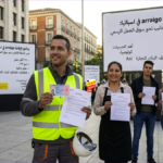 متقاعدون في إسبانيا يبتسمون ويحملون وثائق نظام الضمان الاجتماعي في اسبانيا وتطبيق بنكي يظهر رقم 1,367.40 يورو