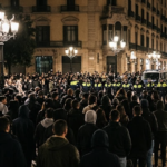 صورة توضيحية لحشد من الأشخاص وعناصر الشرطة خلال تجمع ليلي في ساحة كاتالونيا ببرشلونة.